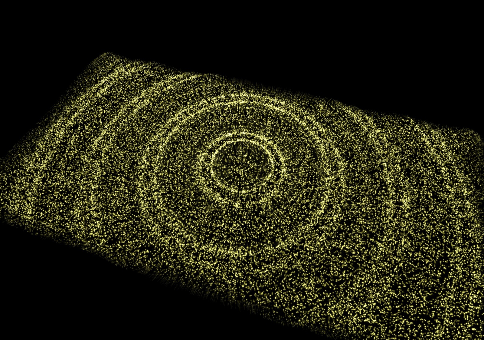 Concentric rings of pale yellow particles spreading across a flat sea, seen from above.